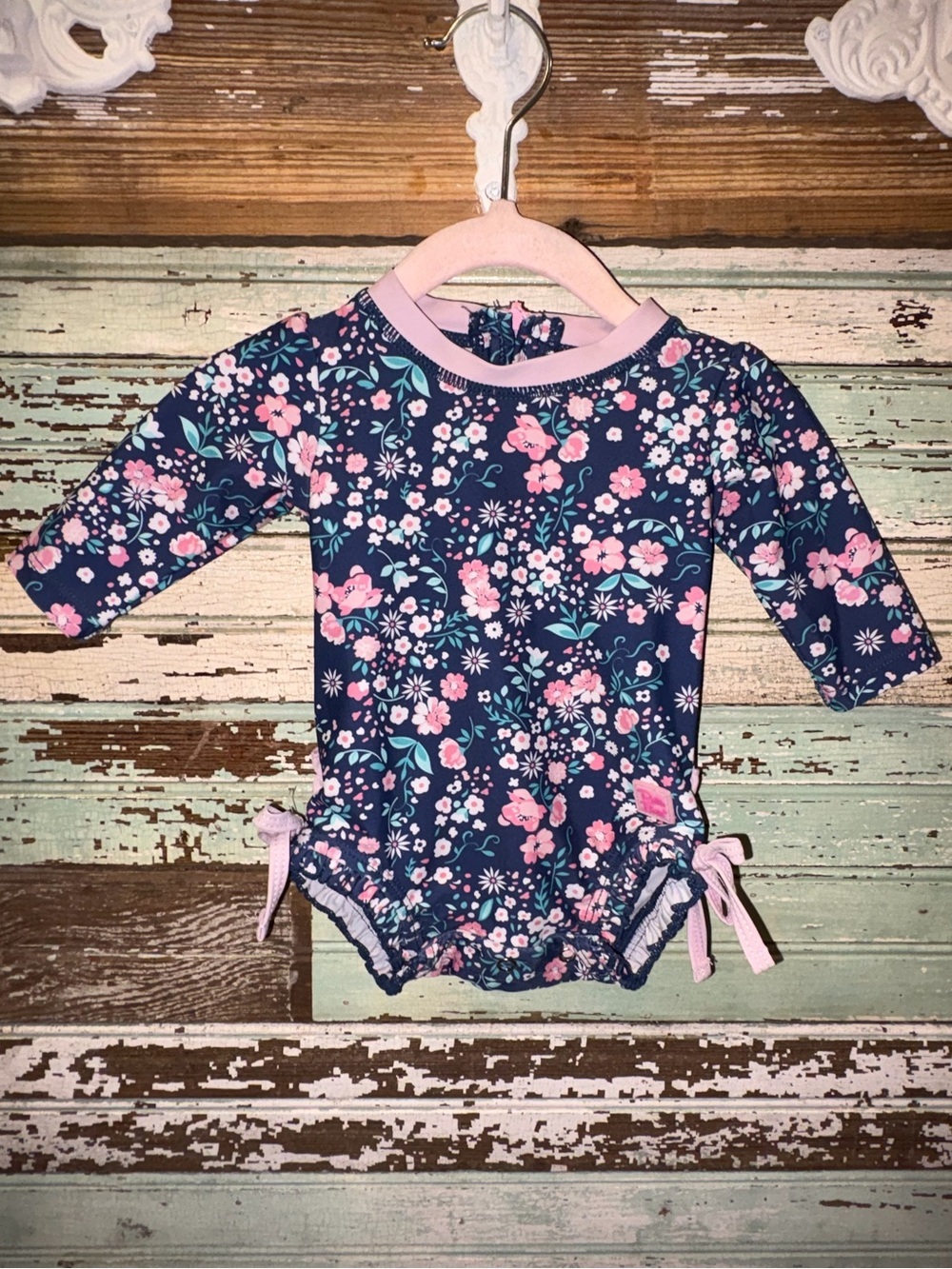 Ruffle Butts Navy Floral Swim Suit with Pink Logo on Bathing Suit